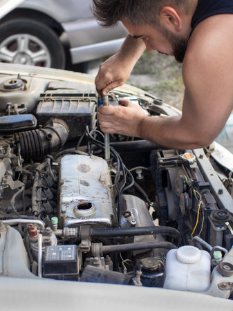 man repairing 4g13 engine on a street, in garage