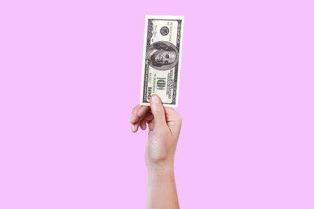 Close up woman hand hold money 100 dollar bill. Money in a hand isolated on violet background