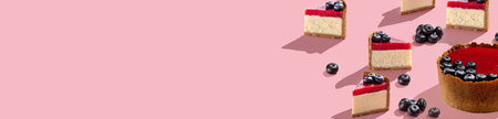 Berry cheesecake banner on pink background. Pattern tasty pieces and blueberry. Copy space for your text. Confectioner concept. Top viewの写真素材