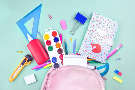 Back to school concept. School supplies are collected in a backpack. Pastel colors flat lay bannerの写真素材