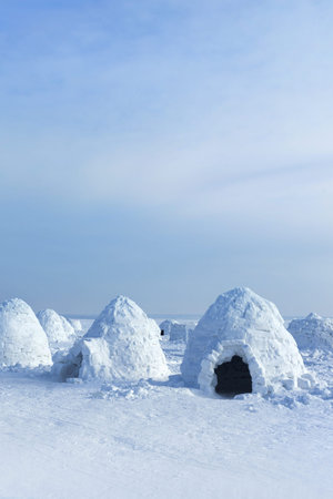 Igloo holiday. Dwelling made of ice and snow. Lots of igloo built, Vertical