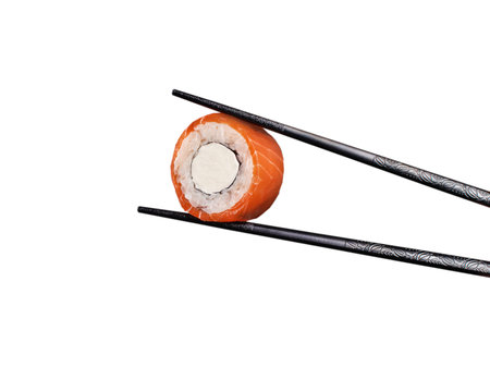Sushi roll hold chopsticks. Salmon and cream cheese. Isolated on white backgroundの写真素材