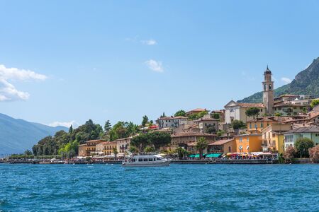 Limone sul Garda, Italy - April 30,2018: Picturesque view of Limone sul Garda, Lake Garda, Italy. Beautiful spring day. Colorful flowers decorating old houses, boats with tourists and restaurants.のeditorial素材