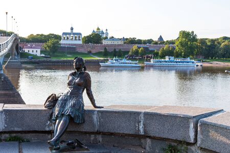 Novgorod, Russia - August 31, 2018: Sculpture of tired tourist girl on the background of the river and the Kremlin. Girl-Tourist Monument. Photo stop in Veliky Novgorod, Russia.のeditorial素材