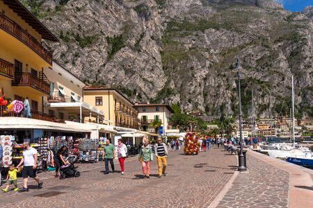 Limone sul Garda, Italy - April 30,2018: Picturesque view of Limone sul Garda, Lake Garda, Italy. Beautiful spring day. Embankment with tourists, cafes and shops.のeditorial素材