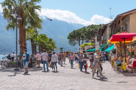 Limone sul Garda, Italy - April 30,2018: Picturesque view of Limone sul Garda, Lake Garda, Italy. Beautiful spring day. Embankment with tourists, cafes and shops.のeditorial素材