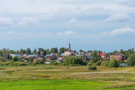 Picturesque summer view of Suzdal, Russia. The Golden ring of Russia. Amazing rural landscape with medieval church, typical rural Russian houses and field.の写真素材