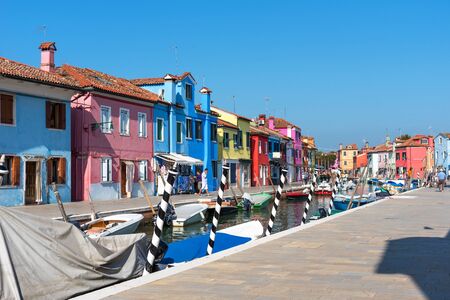 Burano, Italy - September 16, 2019: Picturesque summer scenery view with colourfully painted houses on Burano. Tourists walk along the canals of Burano.のeditorial素材