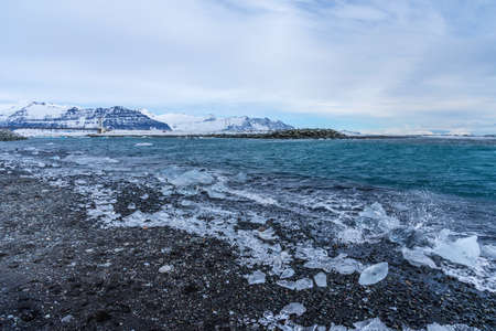 Picturesque winter landscape view of Diamond beach near Jokulsarlon lagoon, Iceland. Amazing picturesque view of black sand beach with iceberg pieces on Diamond beach near Jokulsarlon lagoon in winterの写真素材