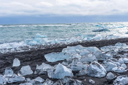 Picturesque winter landscape view of Diamond beach near Jokulsarlon lagoon, Iceland. Amazing picturesque view of black sand beach with iceberg pieces on Diamond beach near Jokulsarlon lagoon in winterの写真素材