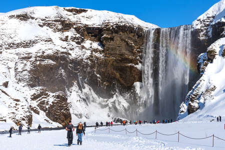 Skogafoss, Iceland - March 5, 2020: Tourists at Skogafoss Waterfall, one of the biggest waterfalls and most popular tourist attractions in Iceland.のeditorial素材