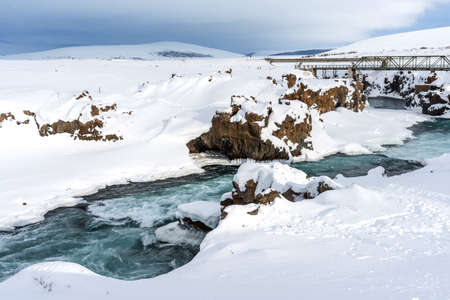 Scenic winter view of Godafoss waterfall in Iceland. Picturesque winter landscape with frozen waterfall in Iceland.の写真素材