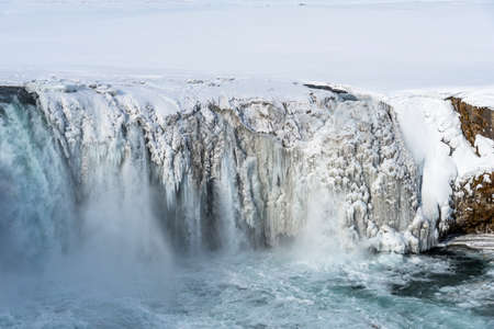 Scenic winter view of Godafoss waterfall in Iceland. Picturesque winter landscape with frozen waterfall in Iceland.の写真素材