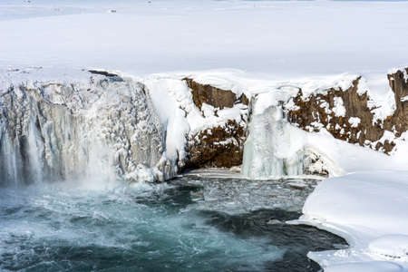Scenic winter view of Godafoss waterfall in Iceland. Picturesque winter landscape with frozen waterfall in Iceland.の写真素材
