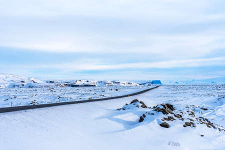Empty asphalt road on background of snowy landscape in Iceland in winter.の写真素材