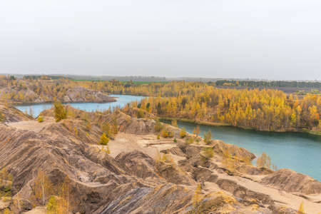 Aerial Autumn view with yellow trees, picturesque hills and blue lakes in Konduki, Tula region, Russia. Turquoise quarry in Romantsevo. Ushakovskiye quarries.の写真素材