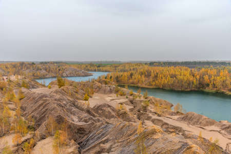 Aerial Autumn view with yellow trees, picturesque hills and blue lakes in Konduki, Tula region, Russia. Turquoise quarry in Romantsevo. Ushakovskiye quarries.の写真素材