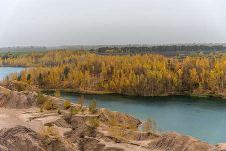 Aerial Autumn view with yellow trees, picturesque hills and blue lakes in Konduki, Tula region, Russia. Turquoise quarry in Romantsevo. Ushakovskiye quarries.の写真素材