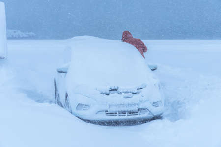 Car under the snow during heavy snowfall. Heavy snowfall and snow-covered car in a snowdrift.の写真素材