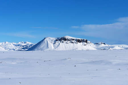 Beautiful winter landscape with mountains covered snow, cold frosty weather and white field in Iceland.の写真素材