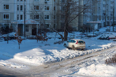 Moscow, Russia - February 18, 2021: Snow-covered cars after heavy snowfall in Moscow. A road in a residential area after a heavy snowfall. The car is covered with snow and is parked in the courtyard of a residential area.のeditorial素材