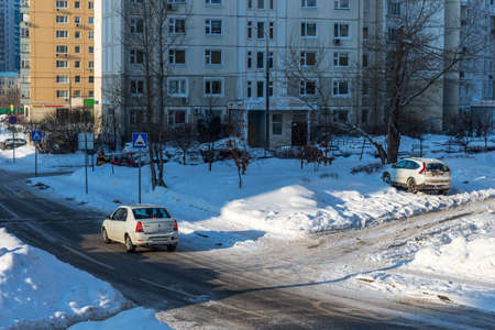 Moscow, Russia - February 18, 2021: Snow-covered cars after heavy snowfall in Moscow. A road in a residential area after a heavy snowfall. The car is covered with snow and is parked in the courtyard of a residential area.のeditorial素材