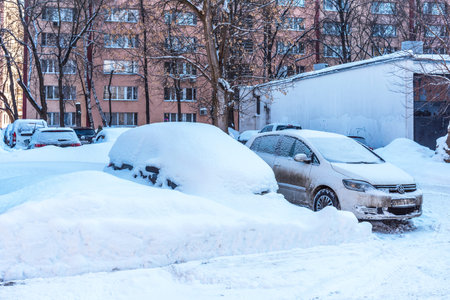 Moscow, Russia - February 18, 2021: Snow covered car after heavy snowfall in Moscow. The car is covered with snow and is parked in the courtyard of a residential area.のeditorial素材