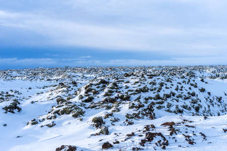Typical Icelandic winter landscape with picturesque blue sky. Beautiful winter landscape with mountains covered snow, cold frosty weather and white field in Iceland.の写真素材