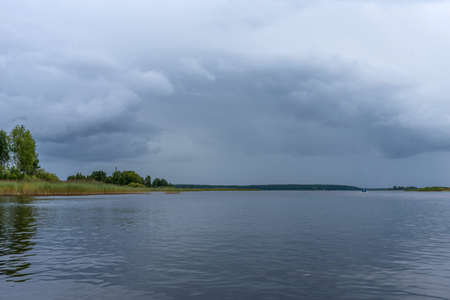 Panoramic summer view of Lake Seliger before a thunderstorm. Forest lake under a stormy sky.の写真素材