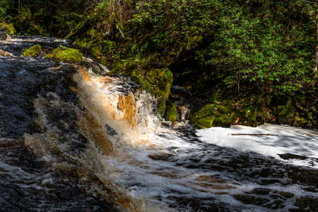 Picturesque autumn view of White Mosty waterfall in Karelia. Amazing landscape with forest waterfall in North of Karelia.の写真素材