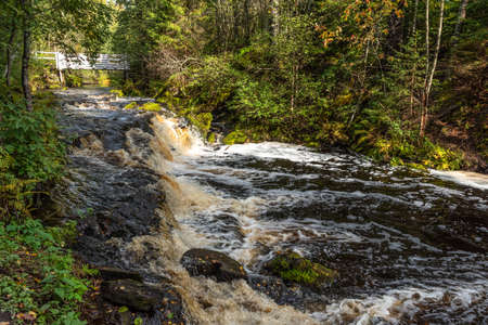 Picturesque autumn view of White Mosty waterfall in Karelia. Amazing landscape with forest waterfall in North of Karelia.の写真素材