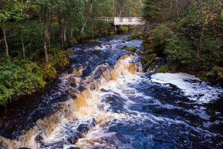 A beautiful view of Jukankoski the highest waterfalls in the Northern Ladoga area. Picturesque autumn view of White Bridges Waterfall in Kareliaの写真素材