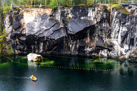 Ruskeala, Russia - September 13, 2021: View of Grand Marble Canyon of Ruskeala mountain park in Karelia. popular tourist attraction. People are boating on the lake.のeditorial素材