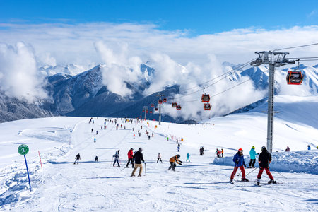 Arkhyz, Russian Federation - January 23, 2024: Tourists ski and snowboard at the Arkhyz resort. Ski lifts in the Arkhyz resort on a sunny day in winter.のeditorial素材