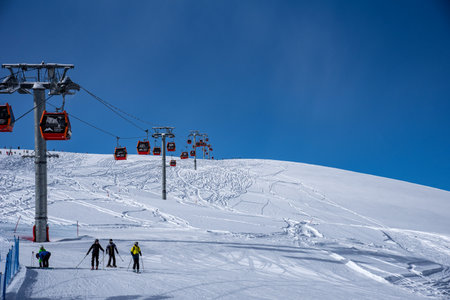 Arkhyz, Russian Federation - January 23, 2024: Tourists ski and snowboard at the Arkhyz resort. Ski lifts in the Arkhyz resort on a sunny day in winter.のeditorial素材