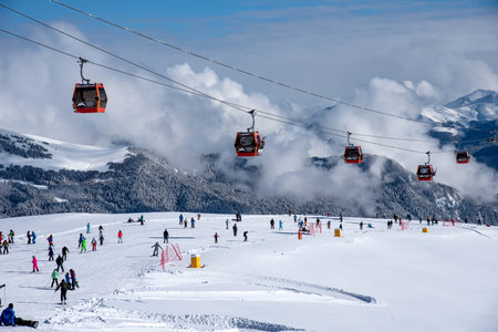 Arkhyz, Russian Federation - January 23, 2024: Tourists ski and snowboard at the Arkhyz resort. Ski lifts in the Arkhyz resort on a sunny day in winter.のeditorial素材