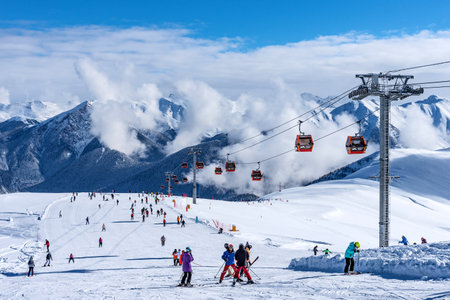 Arkhyz, Russian Federation - January 23, 2024: Tourists ski and snowboard at the Arkhyz resort. Ski lifts in the Arkhyz resort on a sunny day in winter.のeditorial素材