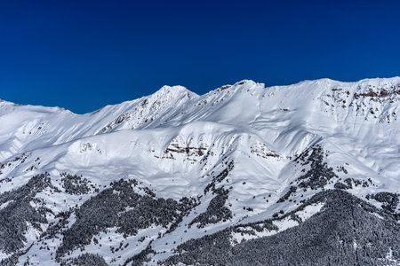 Picturesque winter landscape of the Arkhyz ski resort with mountains, snow, forest on sunny day....