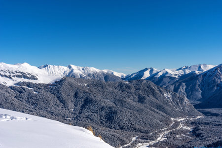 Picturesque winter landscape of the Arkhyz ski resort with mountains, snow, forest on sunny day....