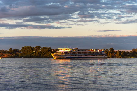 Kalyazin, Russia - July 20, 2022: Beautiful panoramic view of a cruise ship at sunset on Volga River. Picturesque sunset landscape on the river.のeditorial素材