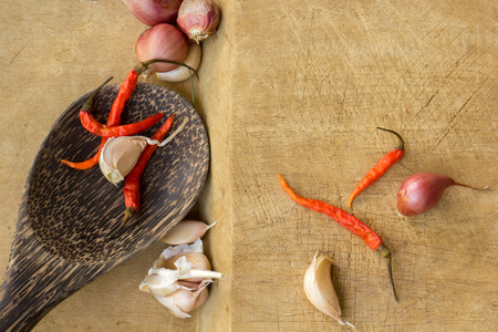 Chilies, shallots, garlic, spices, utensils, surfaces, flooring.の写真素材