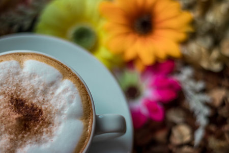Cappuccino coffee on wooden table and sunlight background