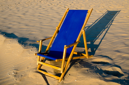 blue wooden chair on sandy beach dutch north seaの写真素材