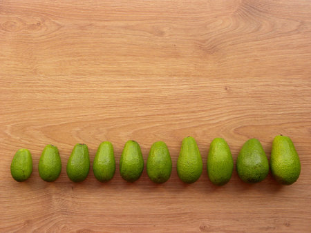 A row of ripe green avocados from small to large