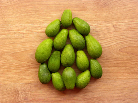 Bunch of green avocados on a wooden background.