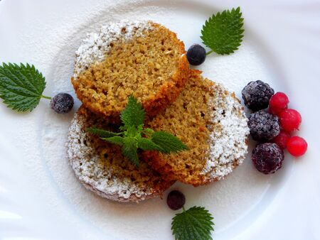 cupcake with berries on a white plate on a white backgroundの写真素材