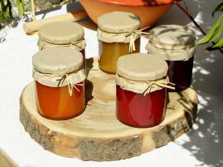 jars of jam on a round wooden standの写真素材