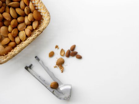 Nutcracker cracks almonds, slices of peeled almonds on a white backgroundの写真素材