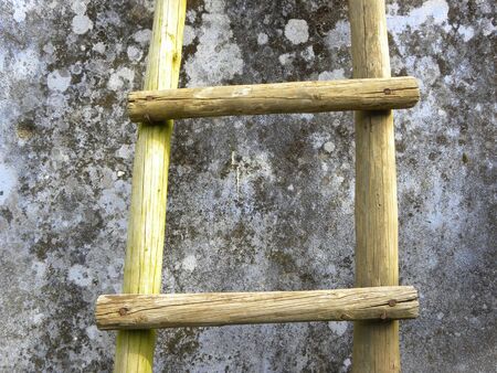 fragment of an old wooden staircase near a gray wallの写真素材