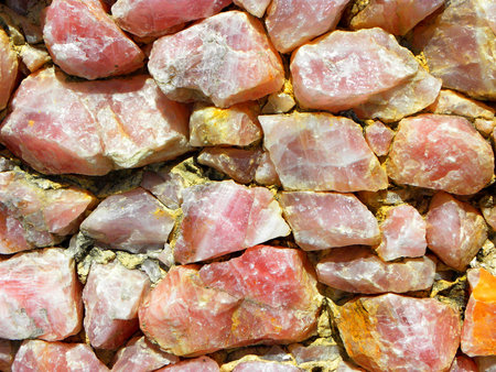 Wall of large natural pink stones. Pink background for wallpaper.